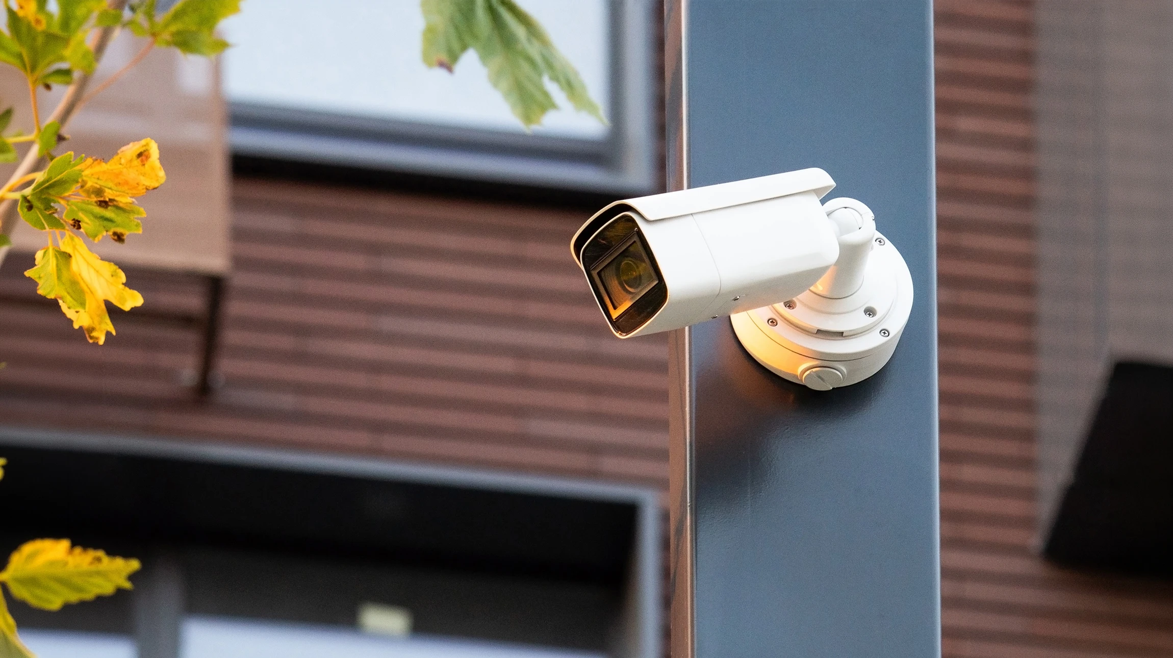 Extérieur urbain moderne avec caméra de vidéosurveillance dôme installée sur poteau métallique blanc